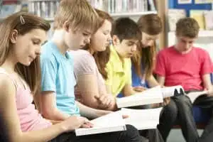 Teenage Students In Library Reading Books