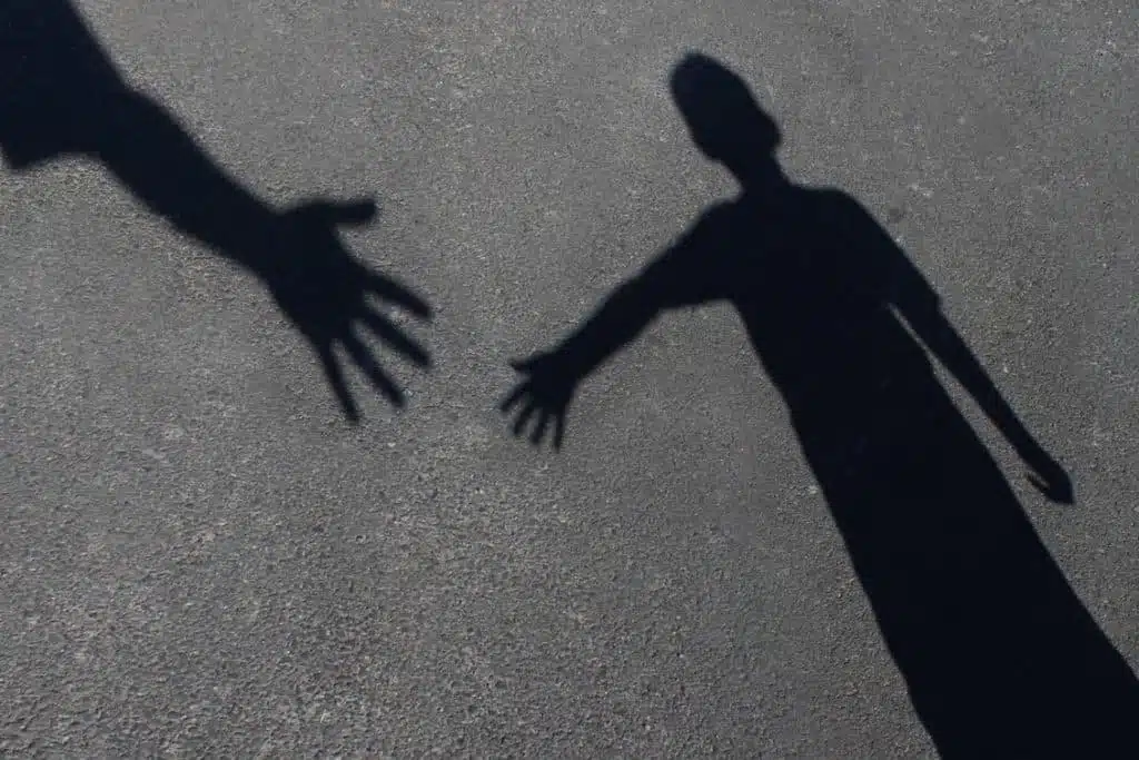 Shadow of two people reaching out