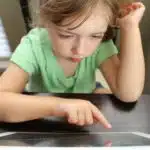 child playing on tablet