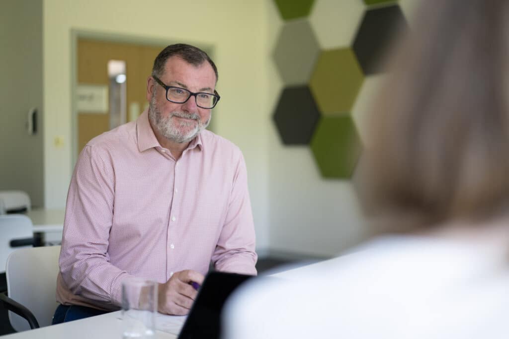 Image of WillisPalmer Chairman Mark Willis sat at a meeting table.